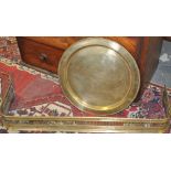 A Victorian brass fender together with a large circular brass tray