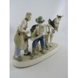 A 20th century continental figure group, two heavy horses with a farrier, W. 40cm.