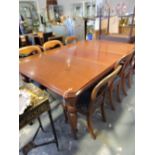 A late Victorian mahogany extending dining table with canted rectangular top on turned tapered legs,