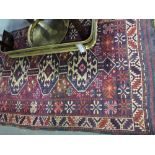 An Iranian Caucasian design rug woven with four octagonal medallions within a geometric field and