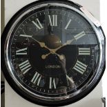 A Victorian style circular wall timepiece, the black dial marked with Roman numerals,