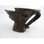 A Chinese horn libation cup, the carved decoration of deer among trees, H. 12cm.