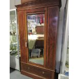 An Edwardian satinwood crossbanded mahogany wardrobe with central bevelled mirrored door over base