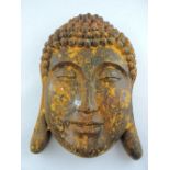 A resin cast Buddhist wall mask, with a cast iron patination H. 46cm.