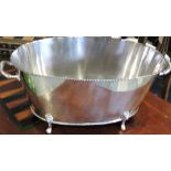 An oval silver plated two handled champagne bath with beaded rims,