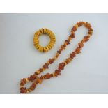 An amber coloured necklace of irregular beads, together with a bracelet, (2).