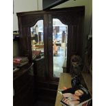 A late Victorian carved walnut wardrobe,