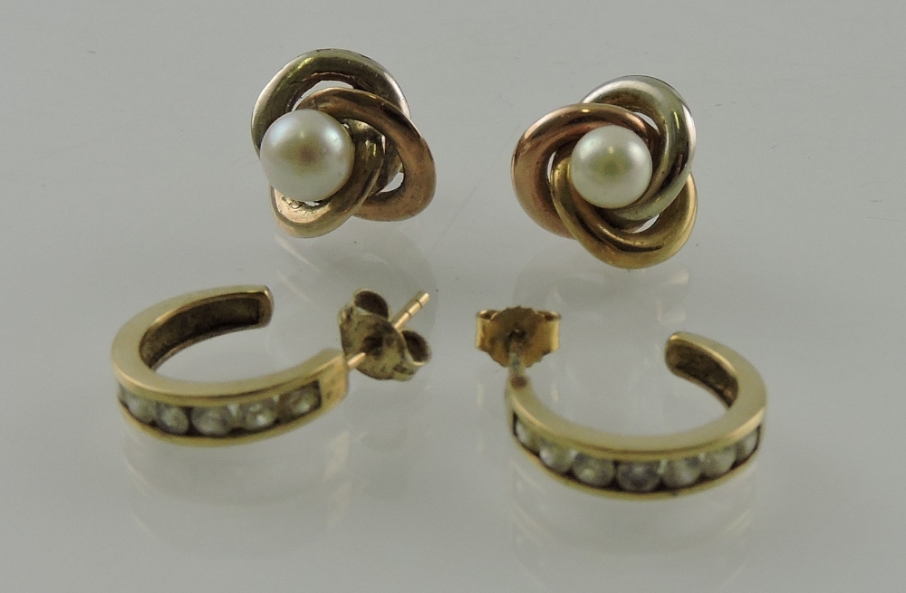 A pair of yellow metal and pearl ear studs, together with another pair set with white stones,