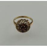 A garnet dress ring, in a pierced and domed yellow metal setting, 3.7g.