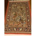 A Persian cream ground silk wool Qum rug, the centre decorated with hunting scene, multi-bordered,