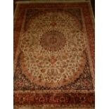 A beige ground Kashan style rug, having central medallion on a floral ground, multi-bordered and