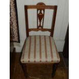 A pair of Edwardian mahogany dining chairs, having a carved and pierced urn design to backrest,