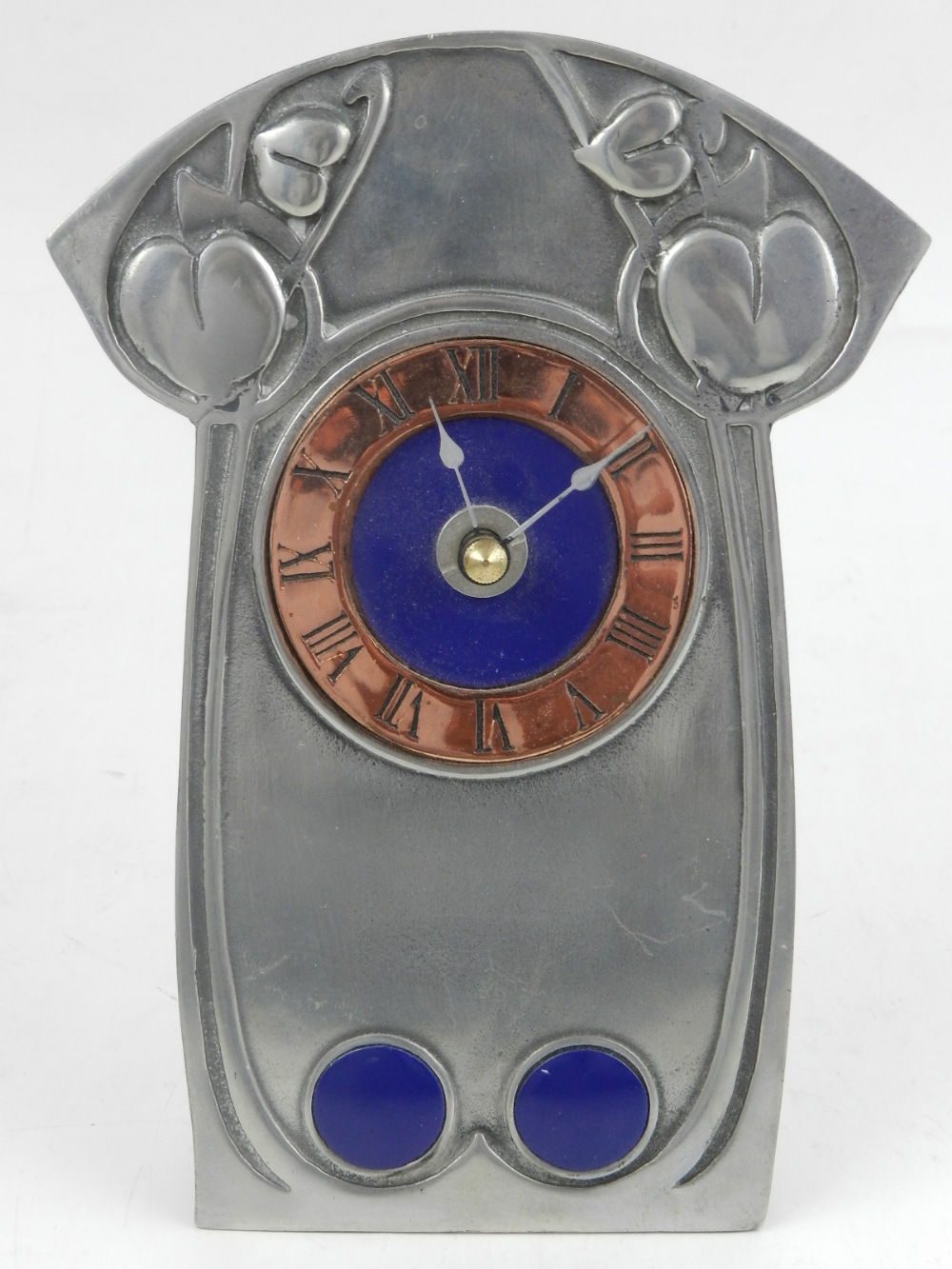 In the Arts and Crafts style, a pewter mantle clock, having copper dial.