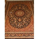 A blue ground Kashan style rug, having central medallion on a floral ground, multi-bordered and