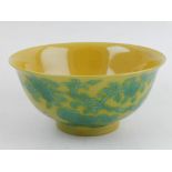 A Chinese yellow ground porcelain bowl, decorated with green vines,