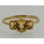 A 9 carat yellow gold and citrine three stone ring.