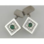 A pair of 18 carat white gold, diamond, and emerald set cufflinks, the round cut central emeralds