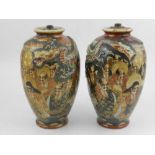 A pair of Japanese satsuma vases, decorated with figures, highlighted in gilt and moulded dragons,