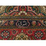 A Persian red ground Kashan rug, having medallion to central on a floral patterned ground,