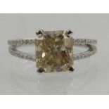 A white gold and diamond ring, set central princess cut central diamond, the shoulders set with