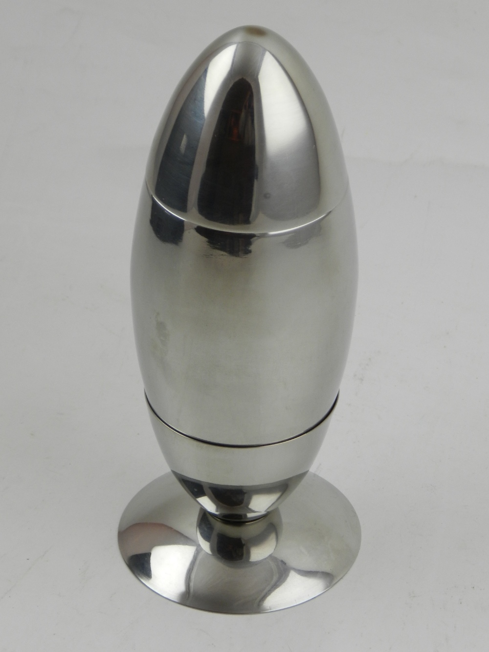 A silver plated novelty cocktail shaker in the form of a missile.