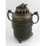 A Chinese bronze twin-handled incense canister with pierced lid, having finials of mounted turtles,