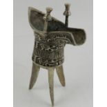 A Chinese white metal wine cup, raised on tripod feet. H.14.