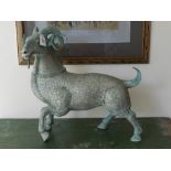 A bronze figural study of a goat, silver inlaid.