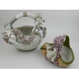 Two Amphora ceramics flower baskets, moulded with encrusted flowers and putti to side,