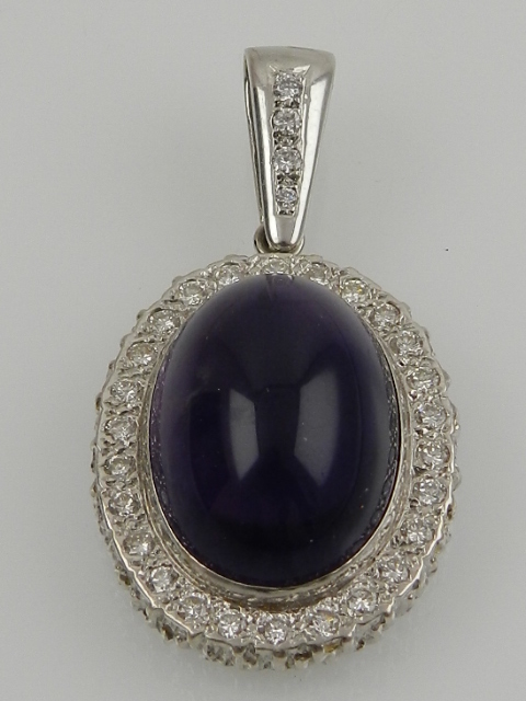 A white metal, diamond and amethyst cluster pendant, the oval cabouchon amethyst surrounded by round