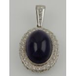 A white metal, diamond and amethyst cluster pendant, the oval cabouchon amethyst surrounded by round