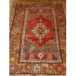 A Turkish prayer rug, having central medallion on a red ground, within many borders. L.160cm W.