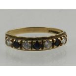 A 9 carat yellow gold, blue and white sapphire seven stone ring.