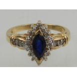 A 14 carat yellow gold, diamond, and sapphire cluster ring, set central marquise cut sapphire.