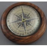 A Victorian style wooden paperweight with floating compass