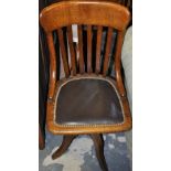 An early 20th century oak office swivel chair, the pad seat upholstered in leather.