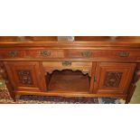 An Edwardian walnut sideboard with an arrangement of three drawers and carved panel doors about and