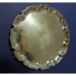 A circular silver card tray on hoof feet, Birmingham 1928,