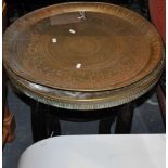 An Egyptian circular brass topped folding occasional table together with an Egyptian brass tray