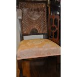 An early 20th century low seat chair, with a fan shaped wicker back and pink upholstered seat,