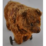 An early 20th Century kapow or straw filled brown bear on wheels