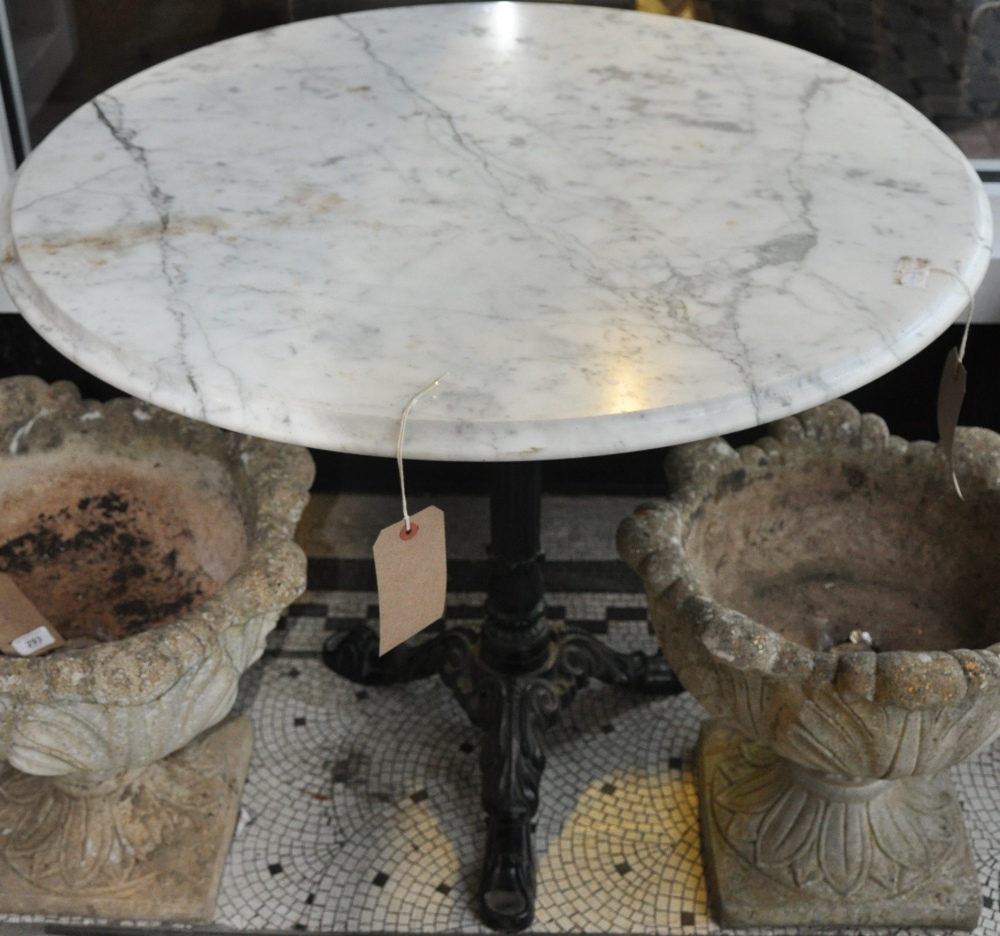 A Victorian style circular marble top garden table on a black painted cast iron base dia:87cm