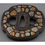 A Japanese tsuba decorated with chrysanthemums