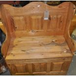 A small panelled pine settle with hinged box seat together with a narrow pine drop leaf table