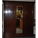 A Victorian mahogany wardrobe with central mirrored door enclosing an arrangement of slides and