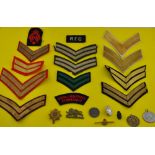 A quantity of British military rank insignia tunic badges, assorted cap badges,