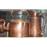 Two arts and crafts copper kettles together with a similar jug