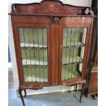 An Edwardian marquetry inlaid serpentine front mahgany display cabinet enclosed by two leaded