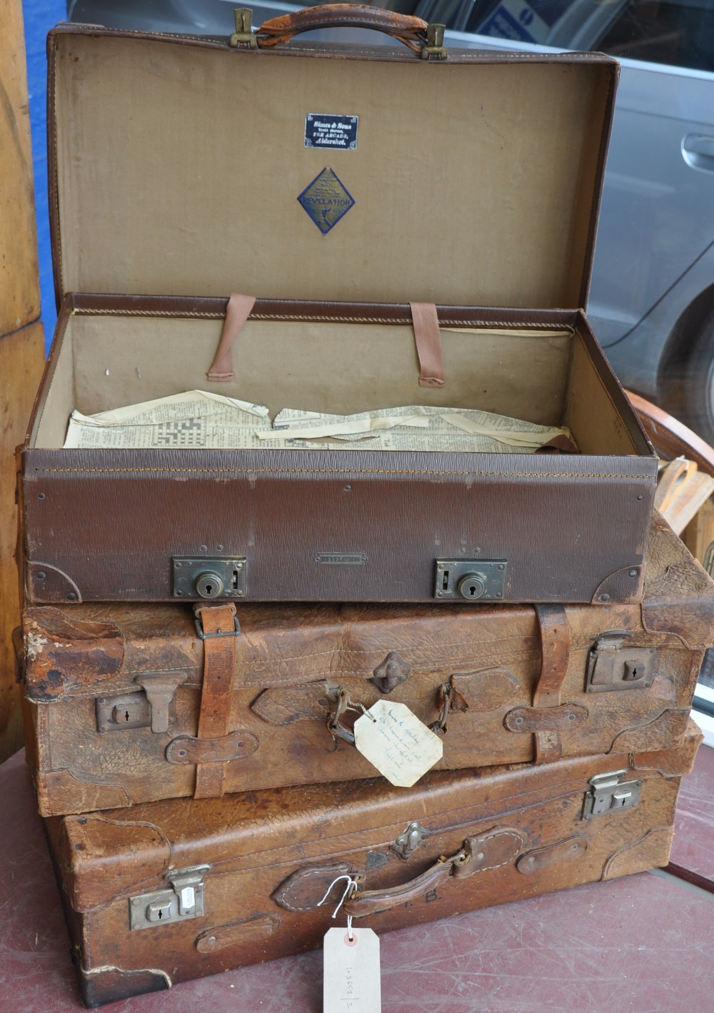 A pair of early 20th Century tan leather suitcases together with a later revelation expanding case