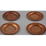 Four North African copper and white metal inlaid dishes, D. 11cm.